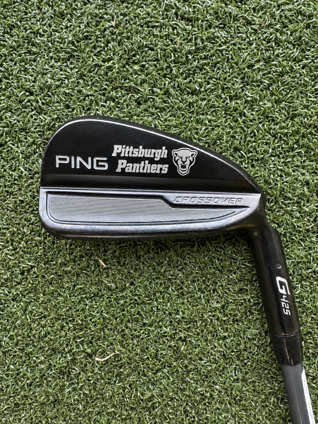 Pittsburgh Panthers text and panther logo engraved on a black PING Crossover golf club